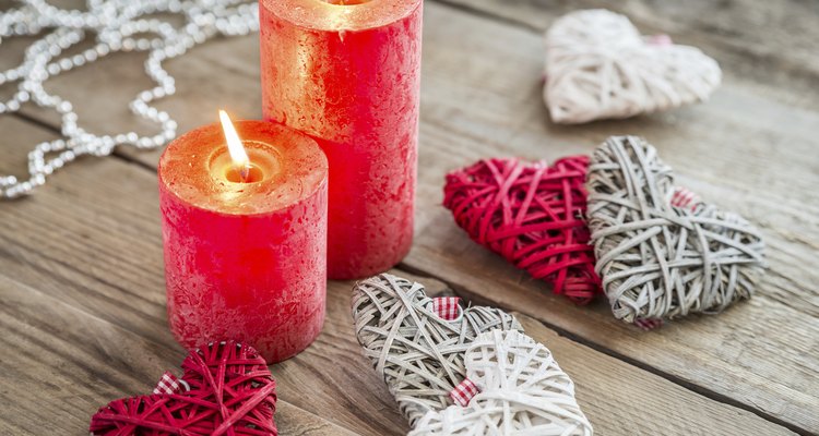Hearts with burning candles on the wooden background