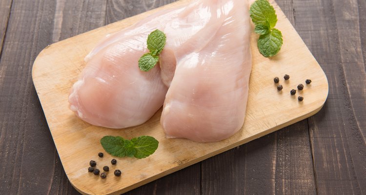Raw chicken breast fillets on wooden background