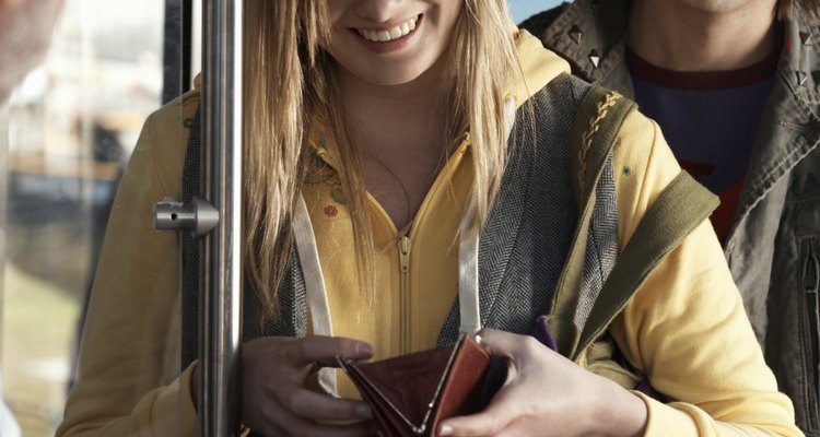 Young woman paying bus fare to driver, smiling