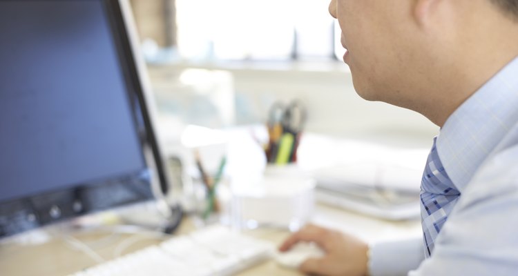 Shot in the UK, businessman wokring at computer
