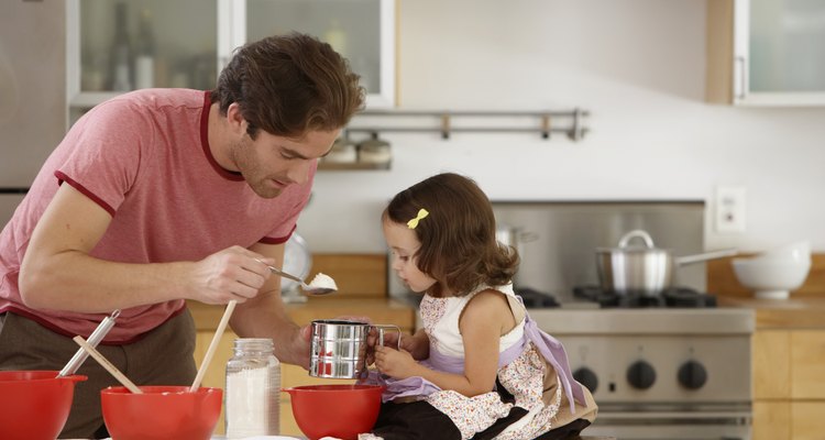 Father and daughter (2-4) baking in kitchen, side view