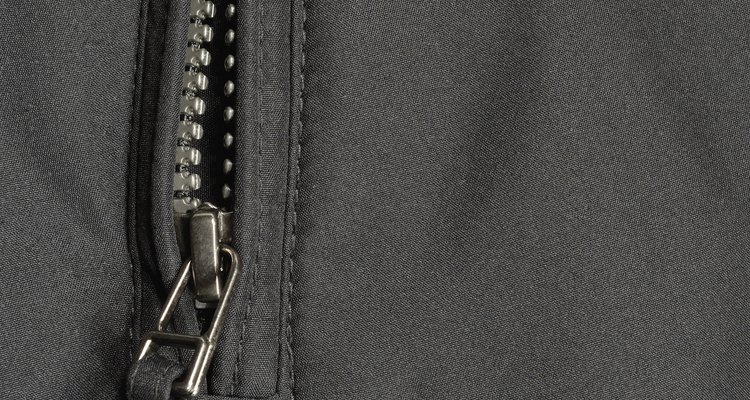 Black polyester twill fabric texture background, open jacket zipper closeup