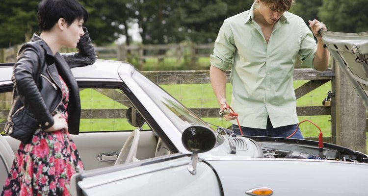 Man and woman jumping car battery