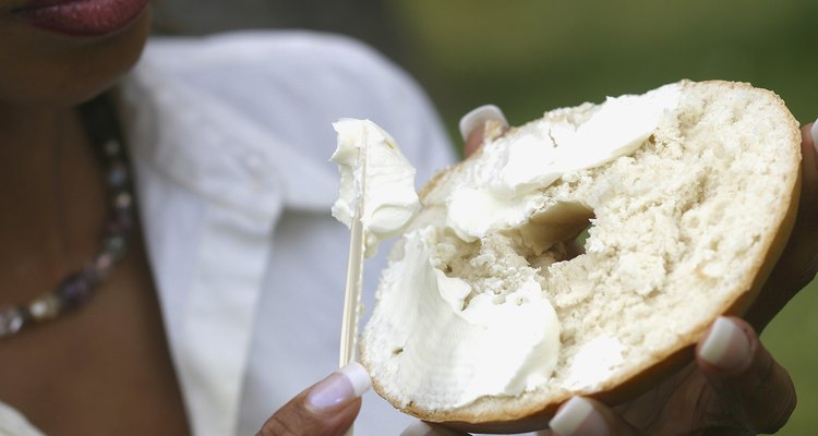 Close-up of a young woman holding a bagel