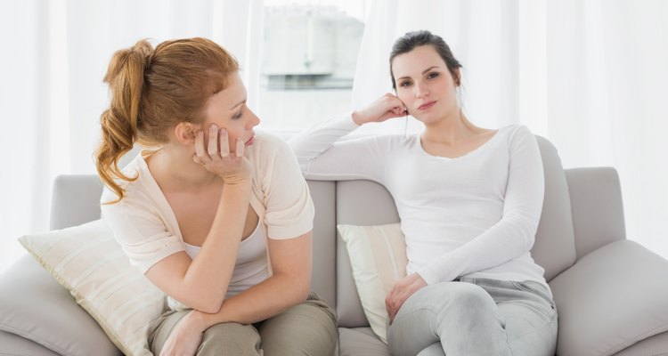 Unhappy friends not talking after argument on the couch