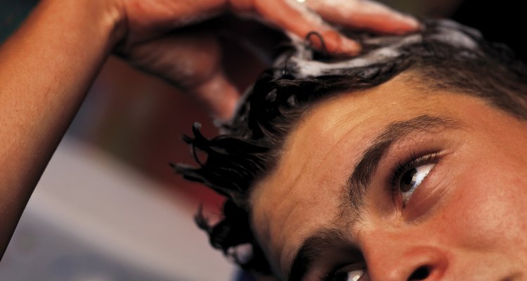close-up of hands washing a man's head