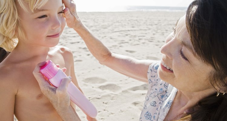 Woman applying sunscreen on boy