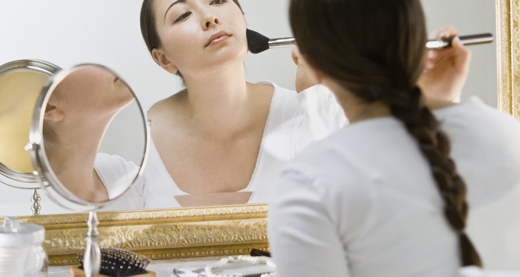 Asian woman applying makeup