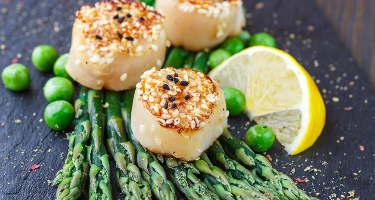 Fried scallops with sesame seeds, asparagus and lemon