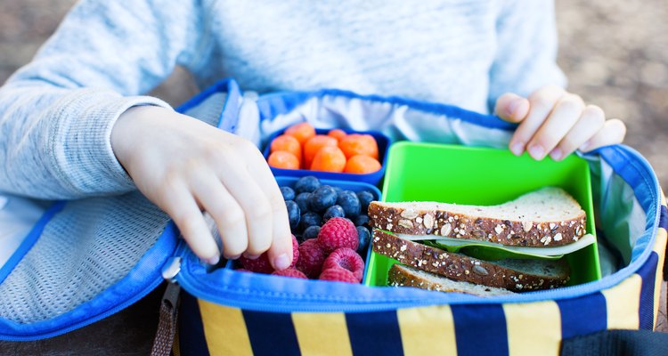Little boy eating snacks from soft-sided insulated backpack