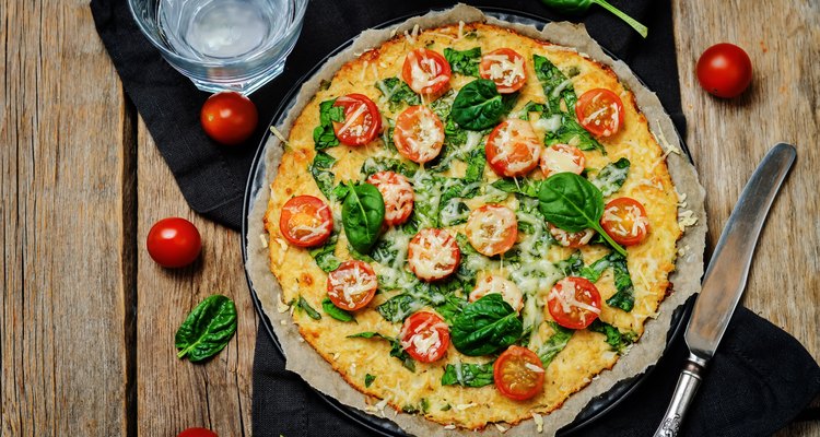 Cauliflower pizza crust with tomato and spinach
