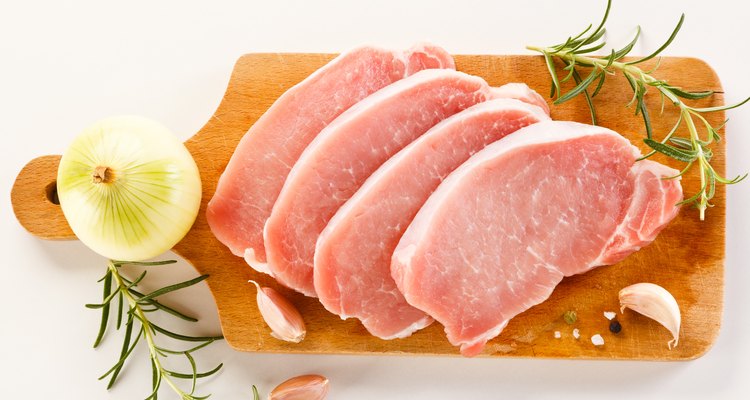 Fresh raw pork on cutting board on white background